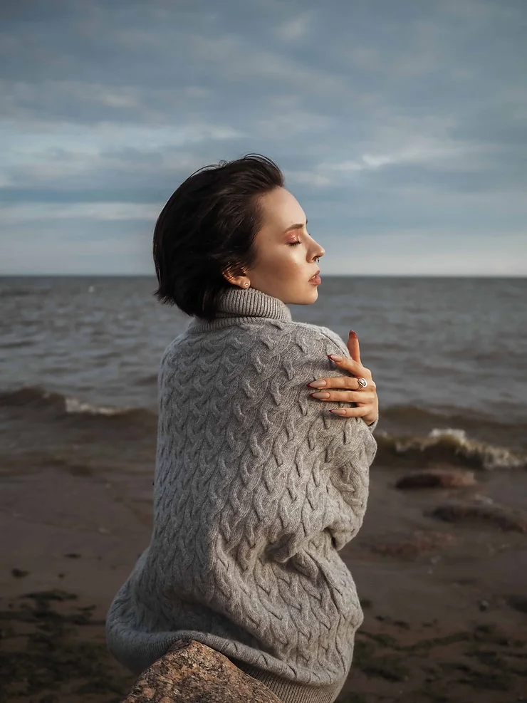 A woman hugging herself on a beach