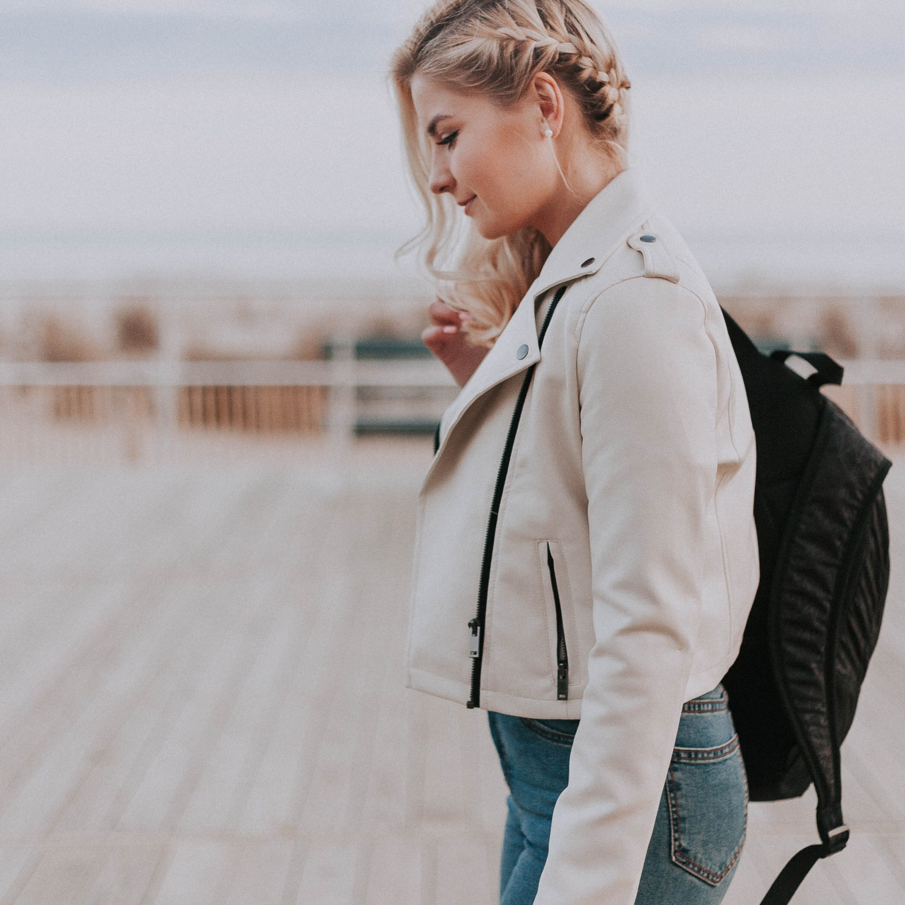 Photo of young woman walking with black backback