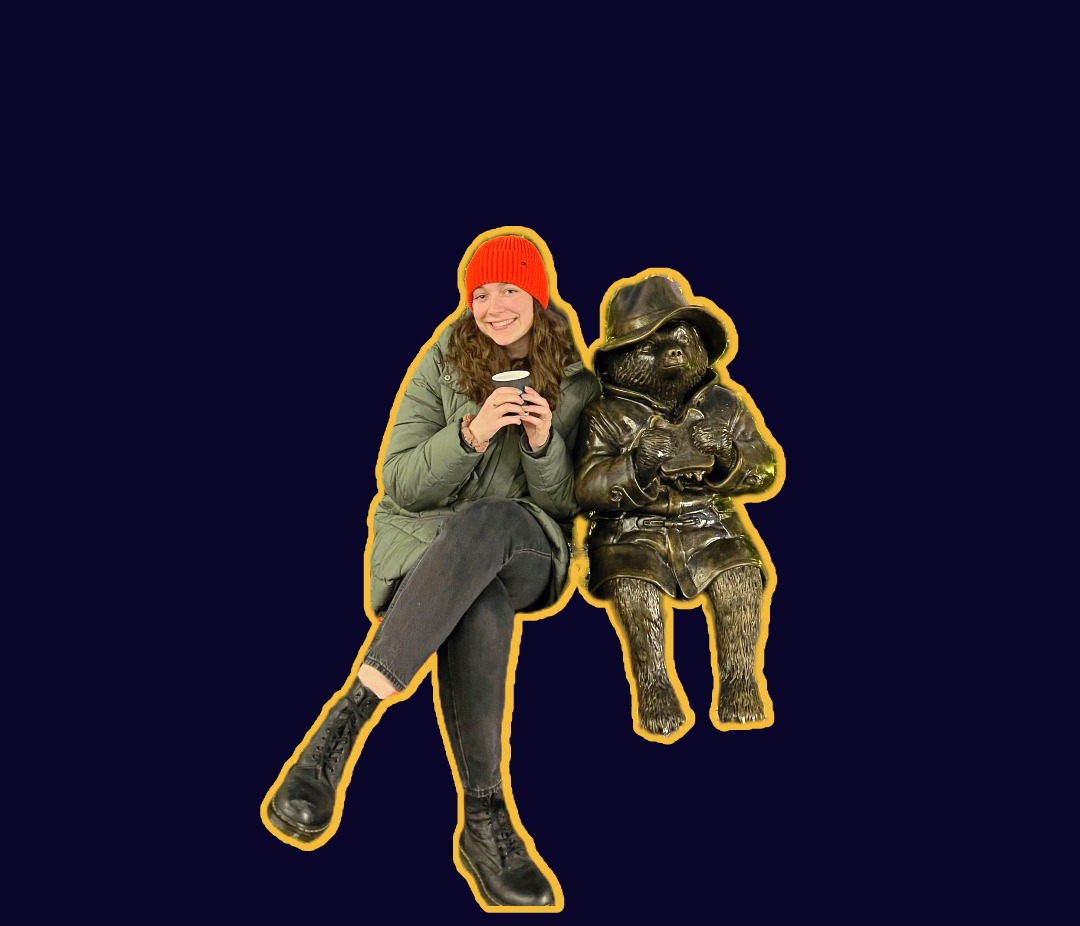 Jack & Grace team member Amelie sits next to a bronze statue of Paddington Bear