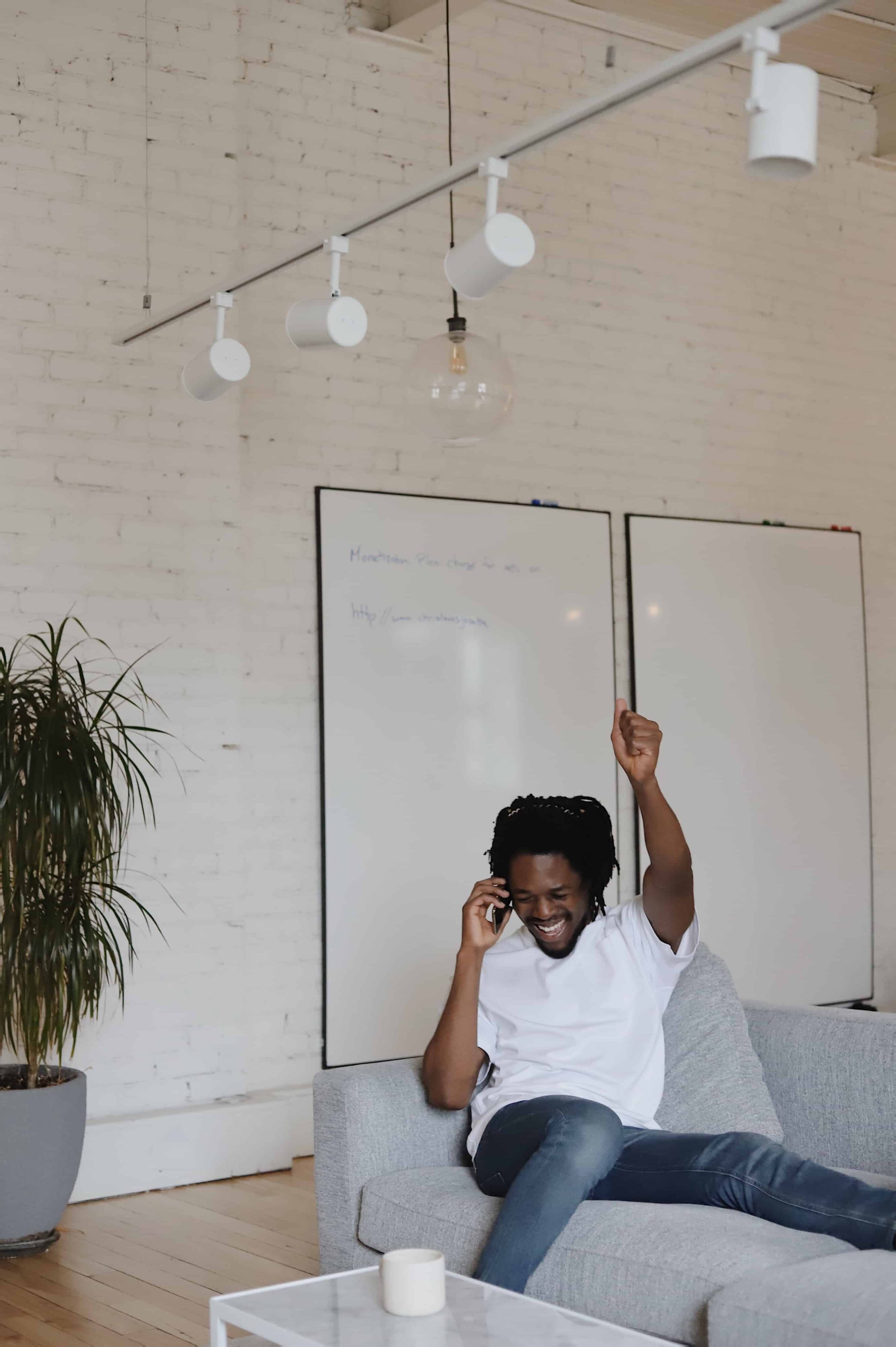 A man on the phone in the office celebrates